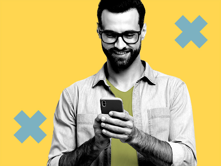 Hombre con barba sonriendo con celular en manos