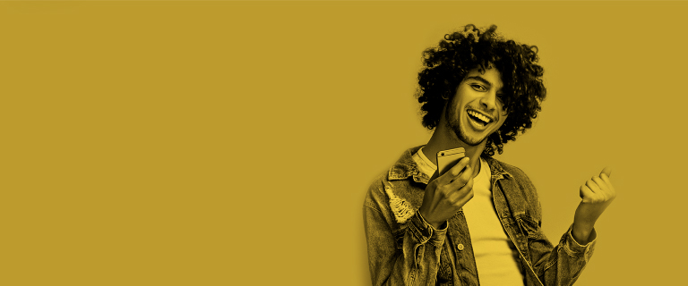 Hombre afro celebra con su celular en la mano