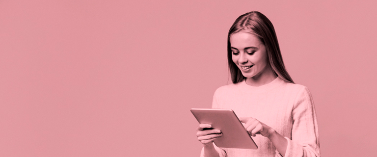 Mujer sonríe leyendo la tablet que está en sus manos