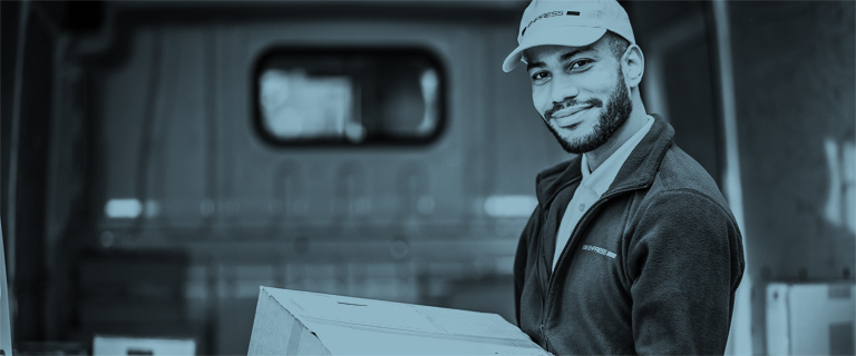 Hombre sonriendo cargando una caja