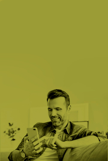 Hombre mayor sonriendo interactuando con celular