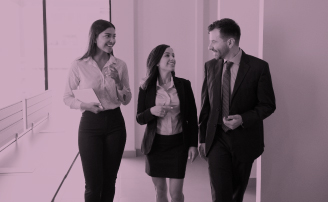 Dos mujeres y un hombre disfrutan hablando por la oficina